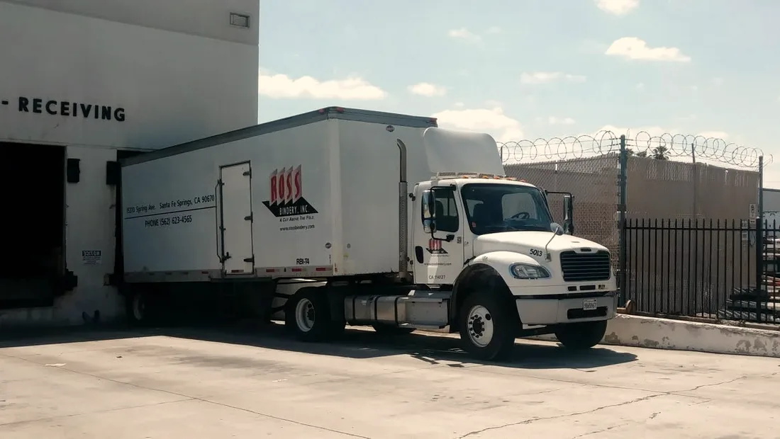 A Ross Bindery box truck backed into the marked receiving bay at a Ross Bindery facility.